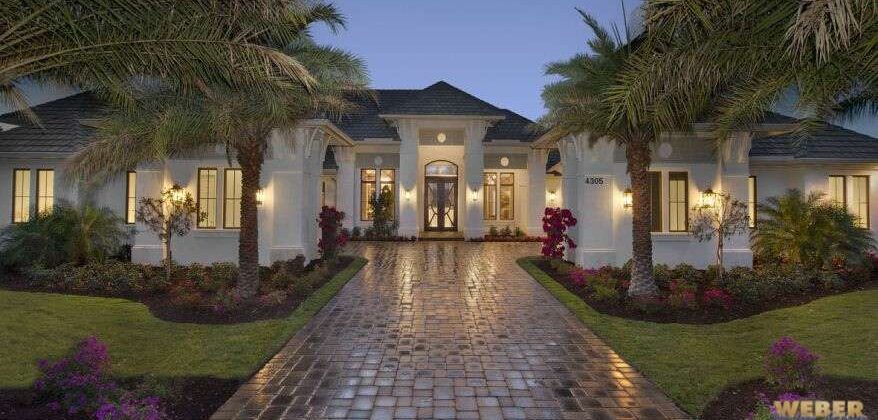 Calusa House Plan exterior showcasing transitional coastal and West Indies architecture with stucco detailing, tall windows, and covered lanai.